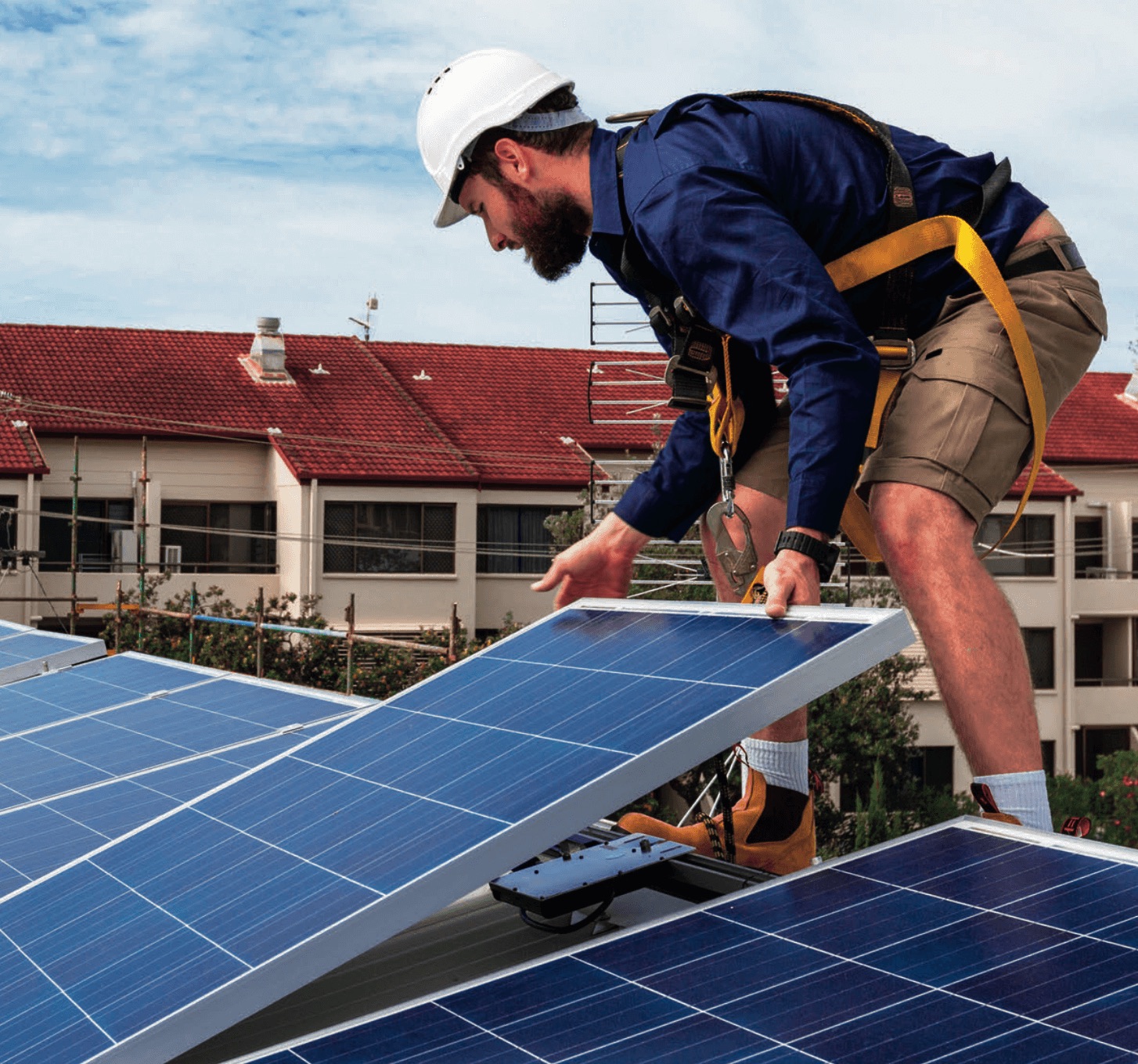 Monteur montiert Solarmodule auf einem Dach